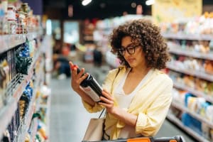 NutriFusion shopper reading a food label in the packaged foods aisle.