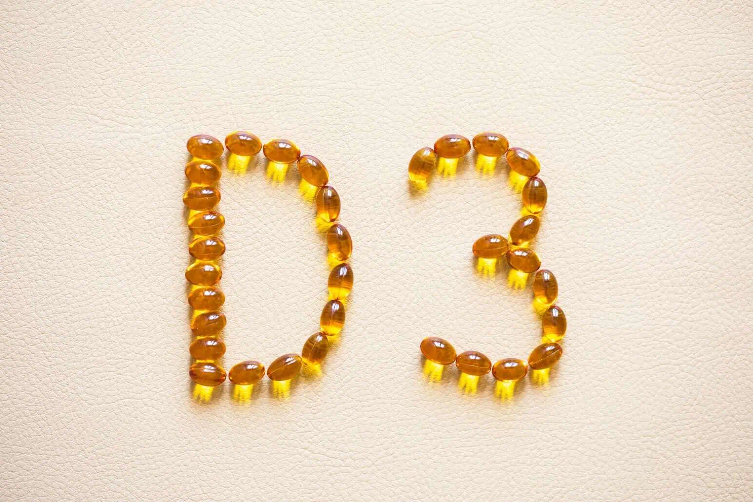 vitamin D3 designed with golden supplement capsules arranged to form the letters “D3”.