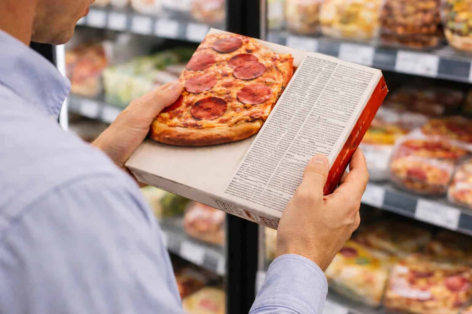 Close-up of packaged food with clean ingredient label being examined in a grocery store.