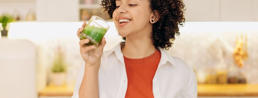 This photo shows a person drinking a plant-based drink for gut health