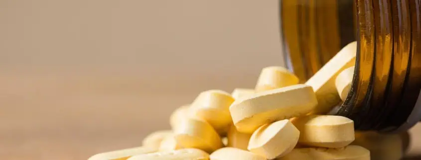 This photo features vitamins pouring out of the bottle